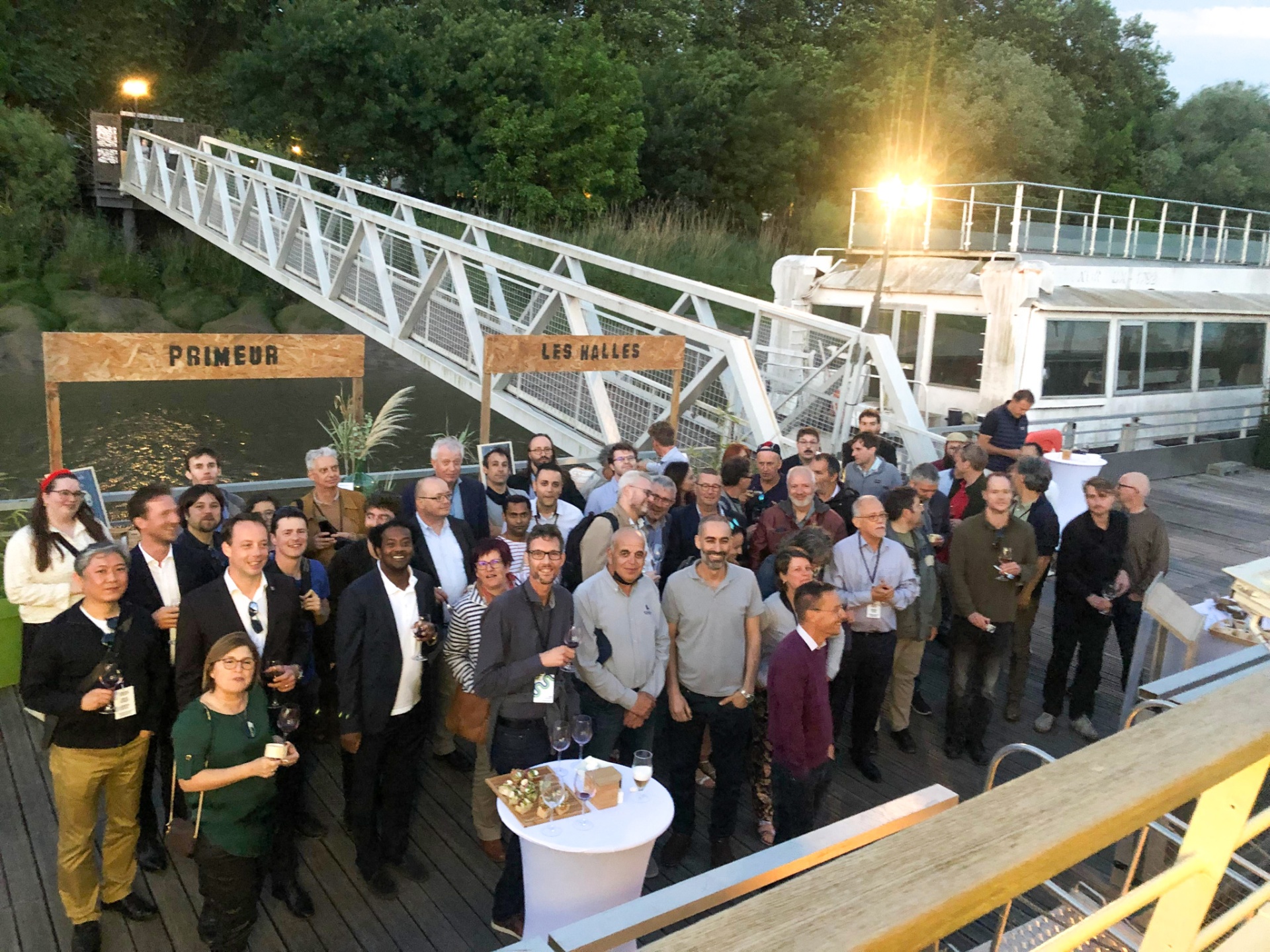 Photo de groupe des chercheurs et experts du congrès LESAM réunis sur un ponton à Bordeaux au crépuscule. - réalisé par Agence Kulte