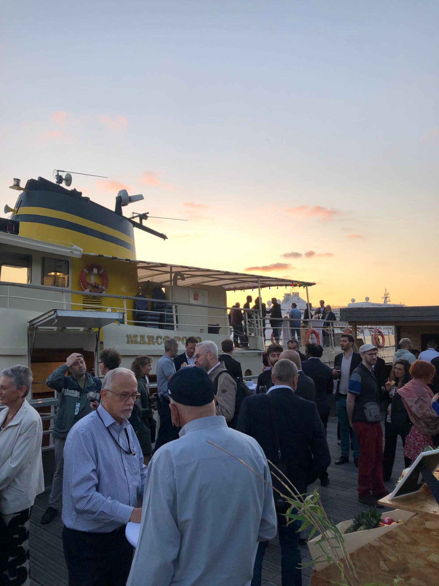 Échanges entre participants lors d'une soirée événementielle sur les quais, à côté du bateau patrimonial Marco Polo. - réalisé par Agence Kulte