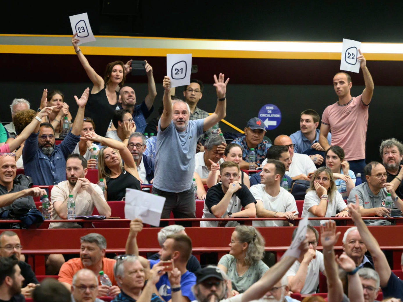 Public engagé brandissant les numéros d'équipe lors du rassemblement Team 2023 — Coupe du Monde de Rugby France 2023 - réalisé par Agence Kulte